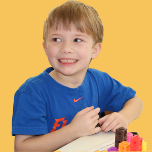 boy smiles while playing with cubes