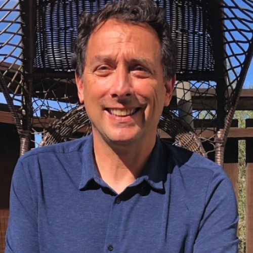 White man in blue shirt smiling